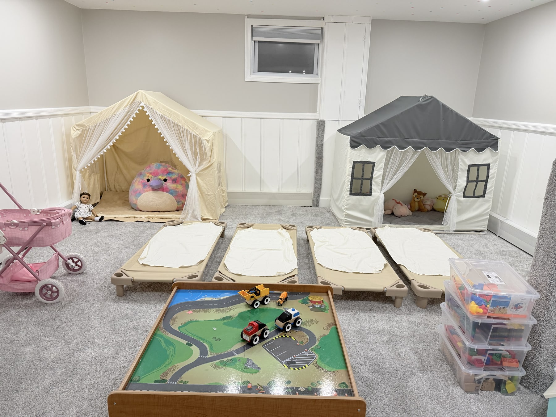 The actual Bluebird Learning Nest toddler napping area with four child-sized cots and two quiet play tents